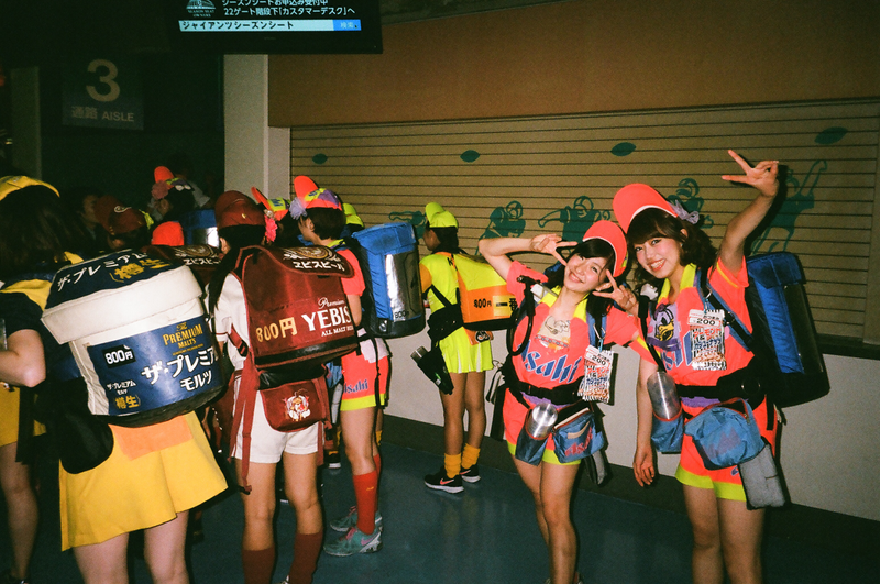 Young ladies provide adult refreshments to baseball fans at the Tokyo Dome.